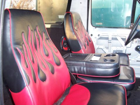 1990 Ford Bronco - Custom interior features flame-patterned seats and a center console with cup holders.