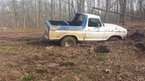 1979 Ford Bronco - This classic Ford Bronco is deeply mired in mud, its tires submerged in the thick, wet earth.
