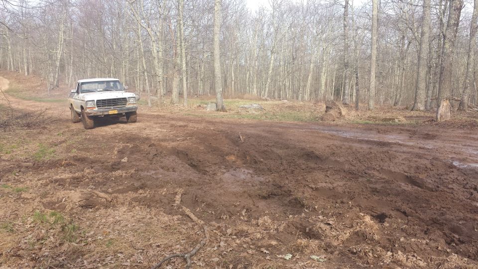 1979 Ford Bronco on a muddy, wooded trail