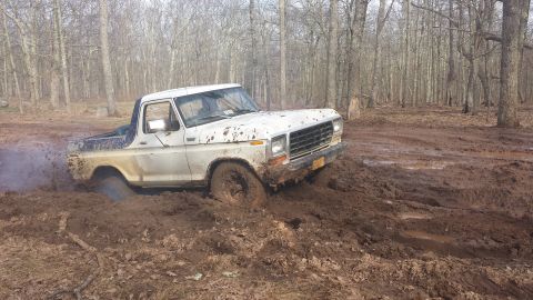 1979 Ford Bronco - This 1979 Ford Bronco is deep in the mud, with smoke coming from the wheel well.