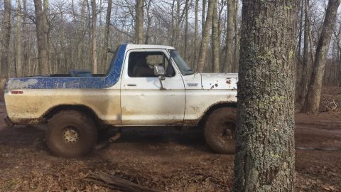 1979 Ford Bronco - This weathered Ford Bronco navigates a muddy, wooded path.