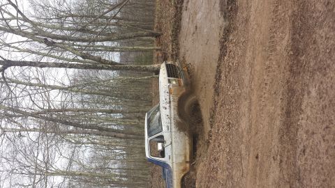 1979 Ford Bronco - A 1979 Ford Bronco navigates a muddy trail, kicking up dirt as it goes.