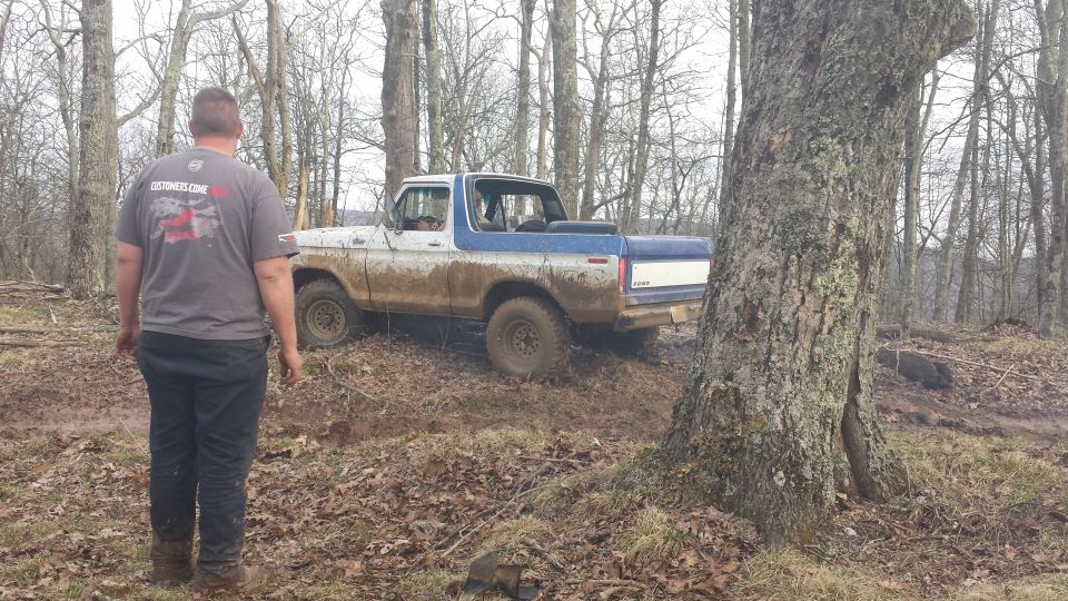 1979 Ford Bronco in 3q-front view, muddy, white and blue