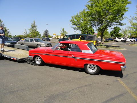 1964 Ford Fairlane - Red 1964 Ford Fairlane coupe being loaded onto a trailer in a parking lot.