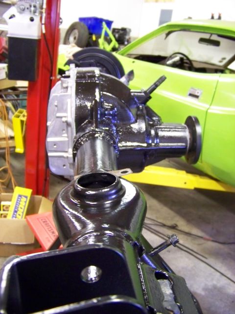 1999 Mercury Grand Marquis - A newly painted rear differential assembly is shown in a workshop, with a green vehicle visible in the background.