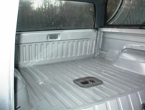 1990 Ford Bronco - The interior of a truck bed, showing the ribbed metal floor and sides after a paint job.