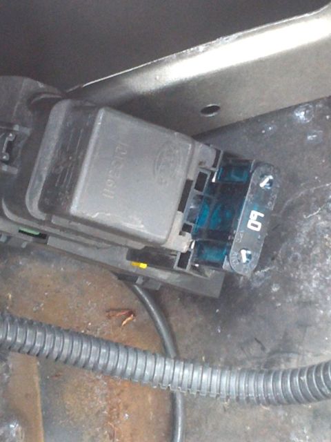 2000 GMC Jimmy - A close-up view of a vehicle's electrical components, including a relay and fuse holder.