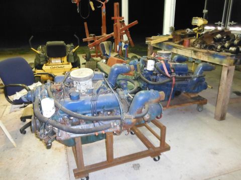 1971 Ford Ranchero - Two V8 engines are displayed on rolling stands in a workshop setting, with a lawnmower and other equipment in the background.