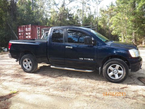 2006 Nissan Titan - Nissan Titan pickup truck with V8 TITAN badging on the side door.