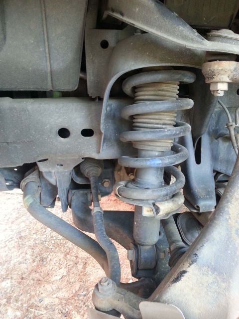 2006 Nissan Titan - This image shows the front suspension components of a vehicle, including the coil spring and strut assembly.