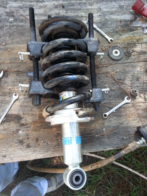 2006 Nissan Titan - A vehicle strut assembly is shown with a spring compressor tool, ready for service or repair.