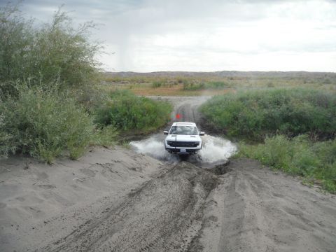 2005 Jeep Wrangler - Pickup truck navigates a water obstacle on a dirt path.