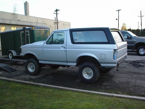 1990 Ford Bronco - This lifted Ford Bronco has a two-tone paint scheme and aftermarket wheels, but the rear bumper is missing.