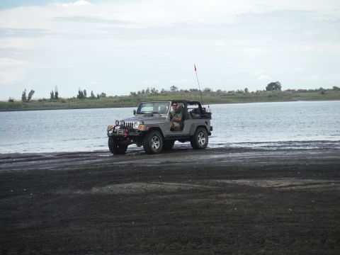 2005 Jeep Wrangler - A Jeep Wrangler is parked on the shore of a lake, with a person inside.