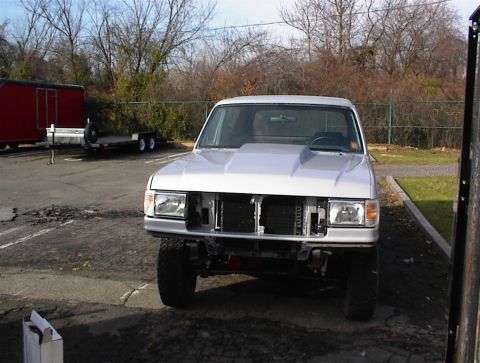1990 Ford Bronco - Silver 1990 Ford Bronco parked outside, undergoing some work.