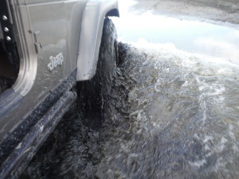 2005 Jeep Wrangler - A Jeep Wrangler navigates through a body of water, kicking up a significant splash.