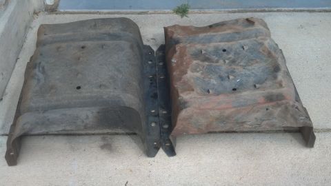 1995 Ford Bronco - Two metal shields, likely for a vehicle's undercarriage, are shown side-by-side on a concrete surface.