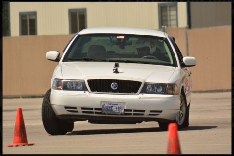 2000 Mercury Grand Marquis - A white Mercury Grand Marquis navigates a course with an orange cone in the foreground.