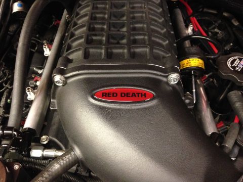 2010 Dodge Challenger - A close-up view of a supercharger unit, identified by the "Red Death" emblem, within an engine bay.
