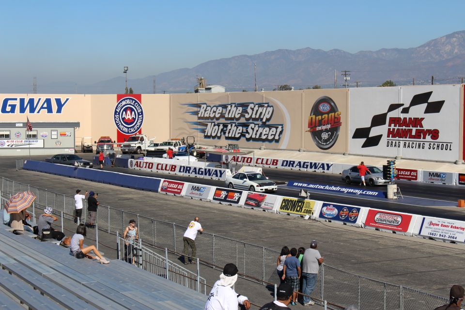 Auto Club Dragway start line with "Race the Strip Not the Street" wall mural