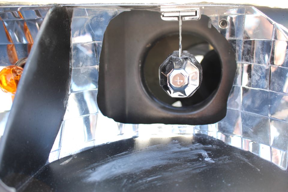Extreme close-up of headlight chrome bulb socket and amber turn bulb