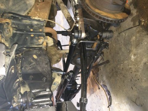 1994 Ford Bronco - Underside view of vehicle suspension components, showing various metal parts and a tire.