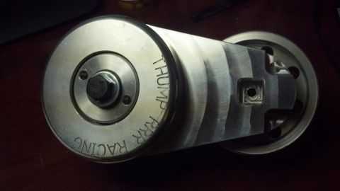 2003 Ford Crown Victoria - cylindrical machined aluminum part engraved 'THUMPRRR RACING' with a square drive recess rests on a wooden desk.