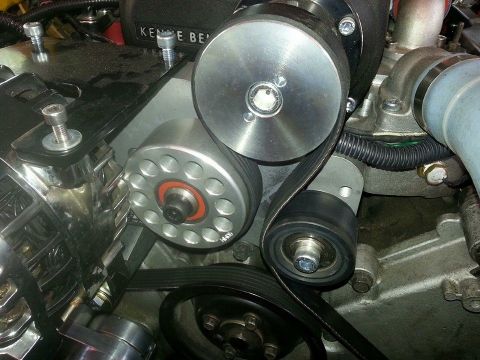 2003 Ford Crown Victoria - large polished idler and a multi-hole drive pulley spin off a Kenne Bell supercharger inside a busy engine bay.