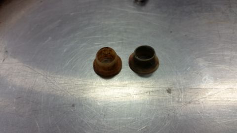 1970 Pontiac Trans Am - Two aged metal bushings sit on a brushed metal surface, showing signs of rust and wear.