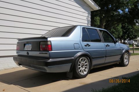 1990 Volkswagen Jetta - Rear view of a blue 1990 Volkswagen Jetta sedan with a spoiler and aftermarket wheels.