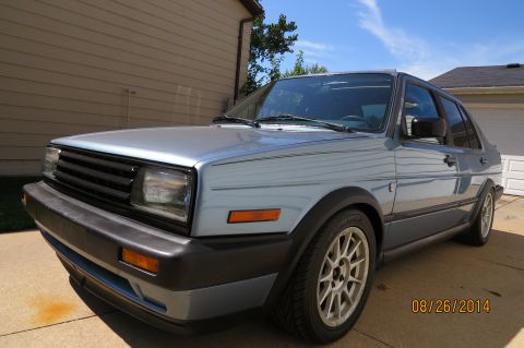1990 Volkswagen Jetta - A light blue 1990 Volkswagen Jetta is shown from the front three-quarter angle in a driveway.