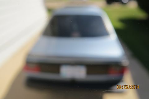 1990 Volkswagen Jetta - The rear of a silver sedan is visible, with a blurred license plate.
