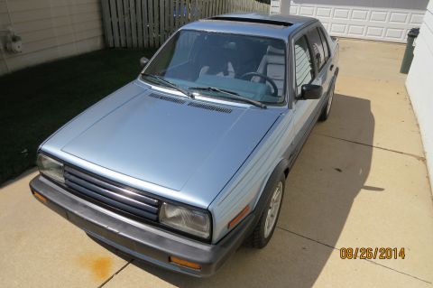 1990 Volkswagen Jetta - This 1990 Volkswagen Jetta is seen in a driveway with a garage and fence in the background.