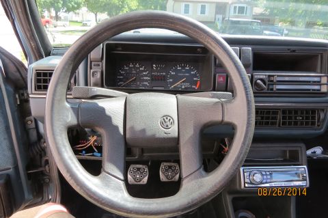 1990 Volkswagen Jetta - The interior of a Volkswagen is visible, showing the dashboard, steering wheel, and pedals.