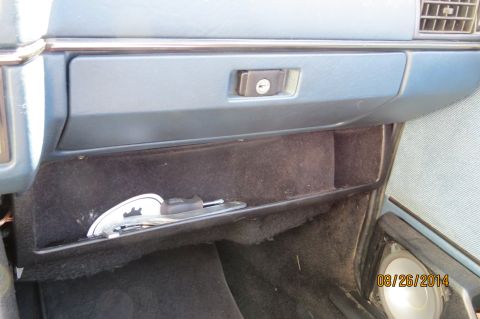 1990 Volkswagen Jetta - The interior of a car shows an open glove compartment with keys resting inside.