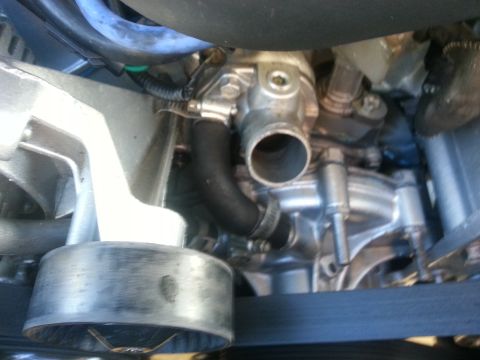 1994 Ford Bronco - Close-up view of an engine's water pump housing and associated hoses.