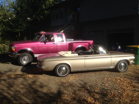 1992 Ford F-150 - A pink Ford pickup truck and a gold convertible are parked side-by-side in a driveway.