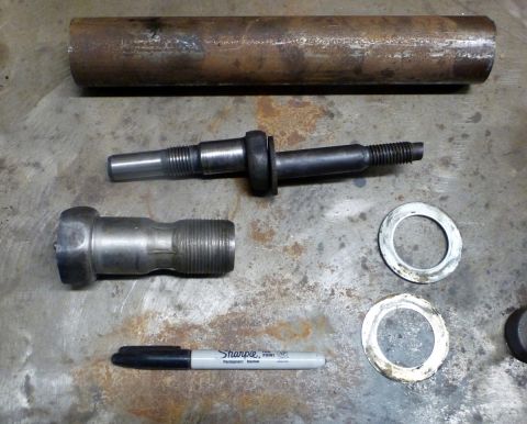 1964 Mercury Monterey - Various metal suspension components and a marker are laid out on a textured surface.
