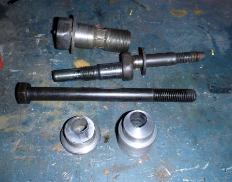 1964 Mercury Monterey - Several metal suspension components, including bolts and bushings, are laid out on a workbench.