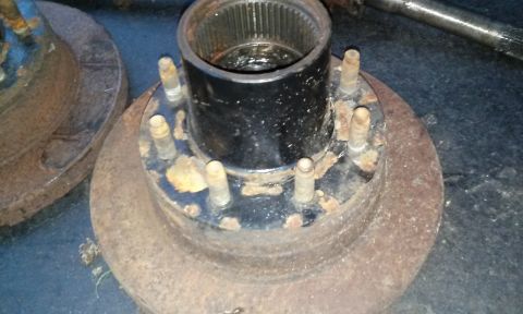 1994 Ford Bronco - A rusty wheel hub assembly is shown, likely for a truck or SUV, with visible lug bolts and a splined center bore.