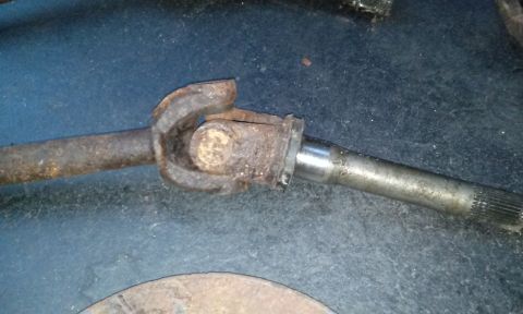 1994 Ford Bronco - Close-up of a rusty driveshaft U-joint and splined shaft.