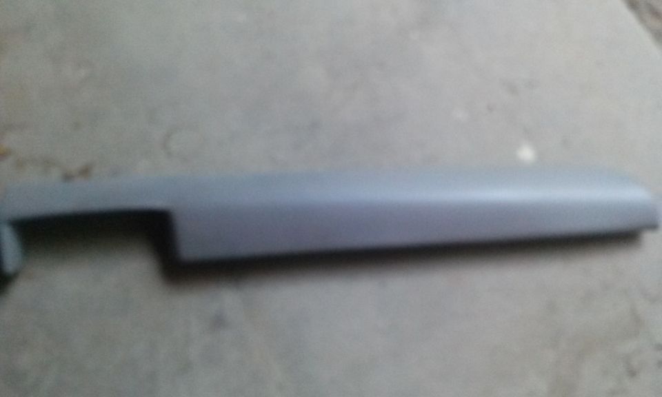 gray plastic trim piece, likely for a car door