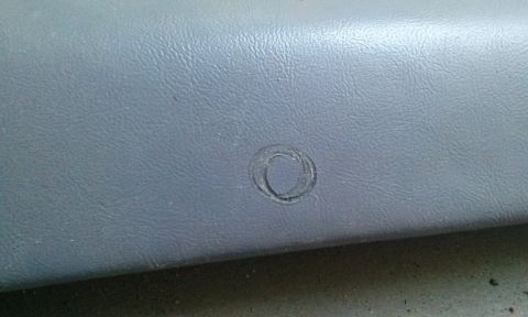 1994 Ford Bronco - Close-up of a gray interior trim panel showing a circular indentation, consistent with a 1994 Ford Bronco.