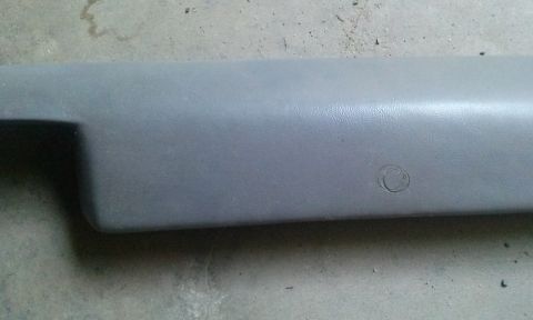 1994 Ford Bronco - Gray plastic interior trim piece with a circular indentation, likely for a button or sensor. The Supermotors logo is visible at the bottom…