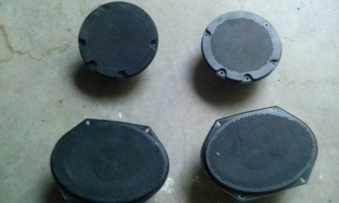 1994 Ford Bronco - Four car speakers are shown on a concrete floor. The image includes a Supermotors.net watermark.
