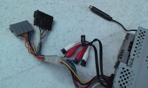 1994 Ford Bronco - Wiring harness and RCA connectors for a car stereo system are laid out on a textured surface.