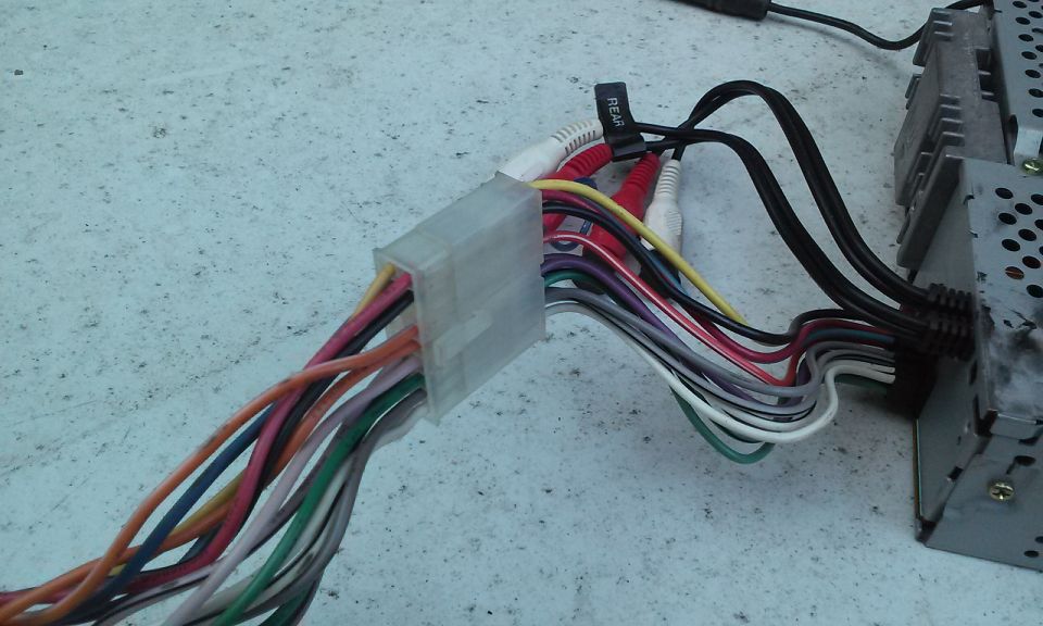 Car stereo wiring harness with RCA connectors and a black label reading 'REAR'