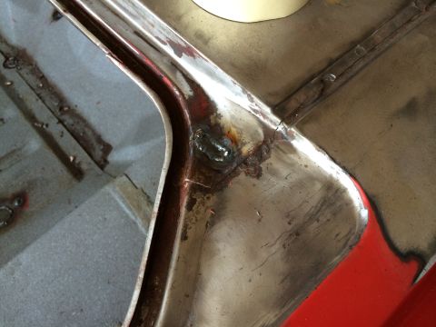 1964 Ford Fairlane - Close-up view of a car's metal body seam, revealing welding work and signs of rust.