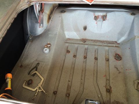 1964 Ford Fairlane - Interior of a car trunk showing repair work with welds and tools present.