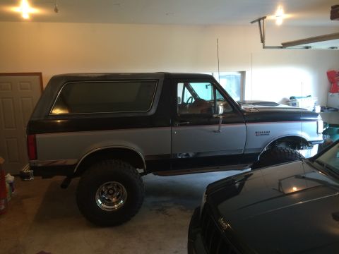 1989 Ford Bronco - This two-tone 1989 Ford Bronco is parked in a garage next to another vehicle.